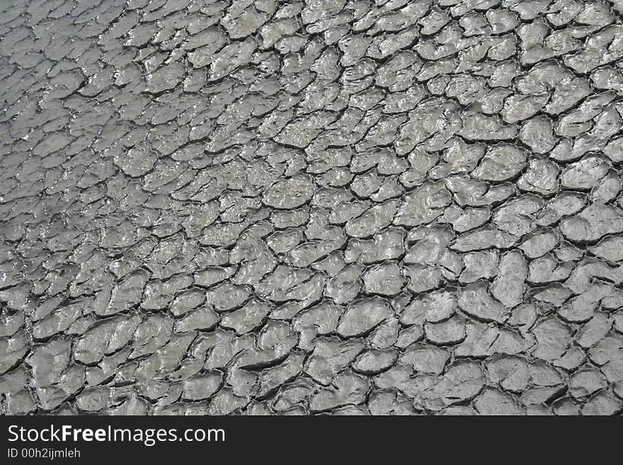 Grey mud texture with cracks and a little water