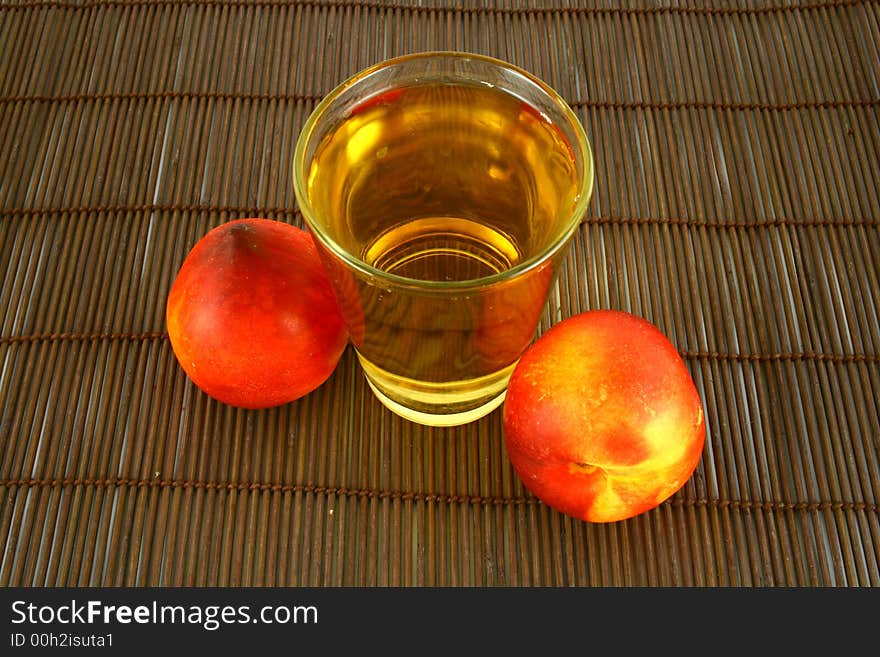 Glass of icetea and nectarine fruit - close-up. Glass of icetea and nectarine fruit - close-up