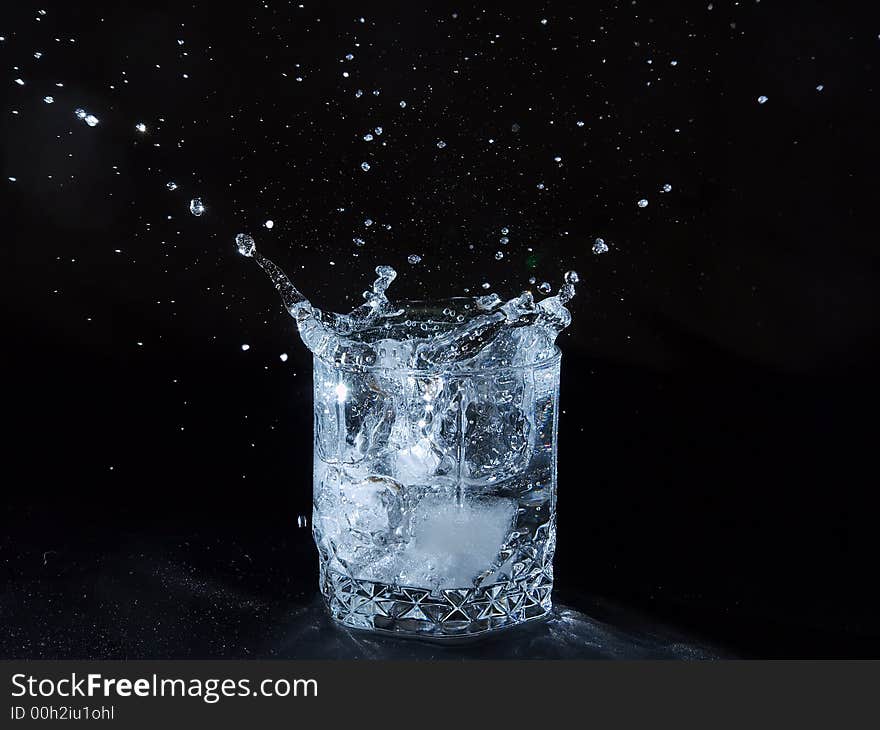 Ice splashing water in the glass