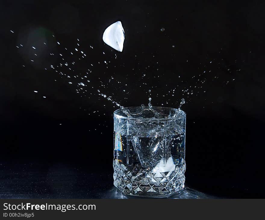 Ice splashing water in the glass