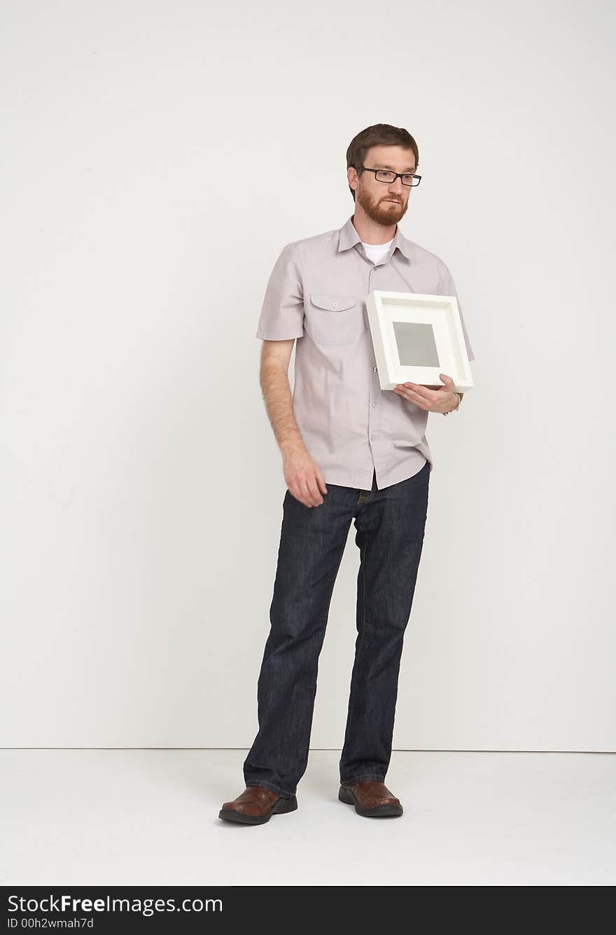 Man with glasses holding a frame with a  sad look of a tribute and loss. Man with glasses holding a frame with a  sad look of a tribute and loss.