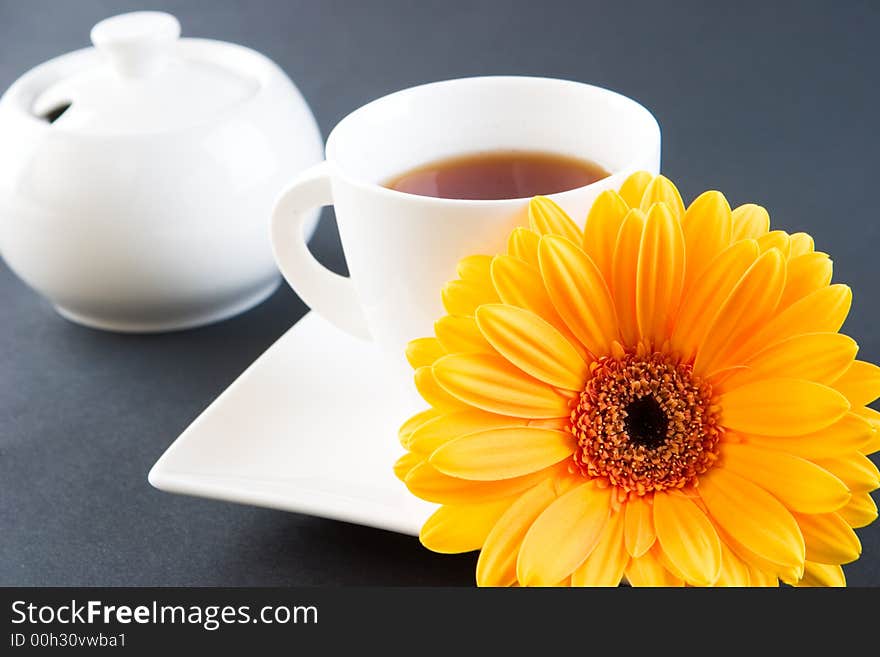 A cup of tea with a gerbera daisy