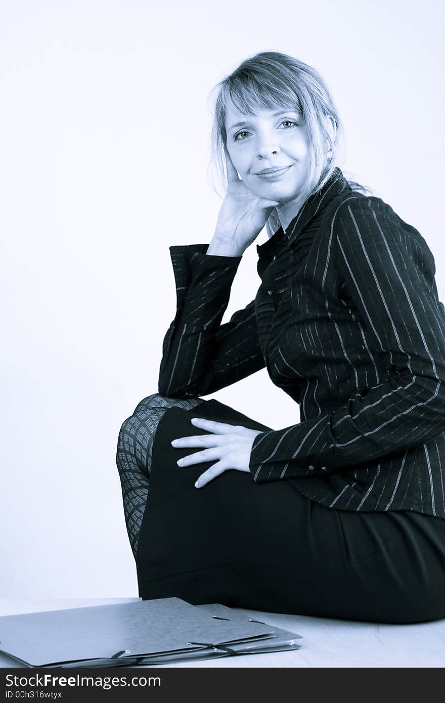 A business woman sitting on a table. A business woman sitting on a table