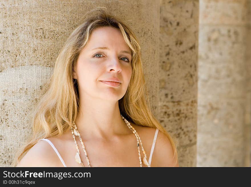 A woman leaning against a pillar. A woman leaning against a pillar