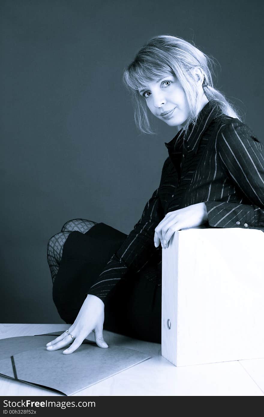 A business woman sitting on a table with a blue tone (2). A business woman sitting on a table with a blue tone (2)