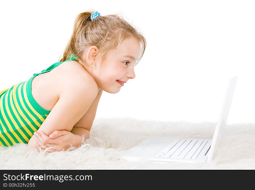 An attractive girl looking at a white laptop on a white rug