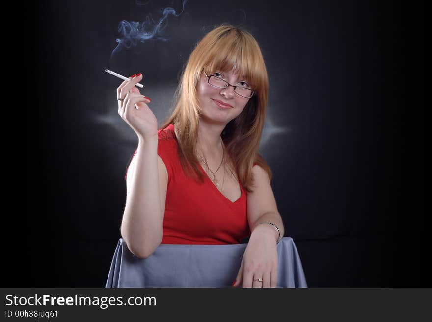 Girl smoking a cigarette on a dark background. Girl smoking a cigarette on a dark background