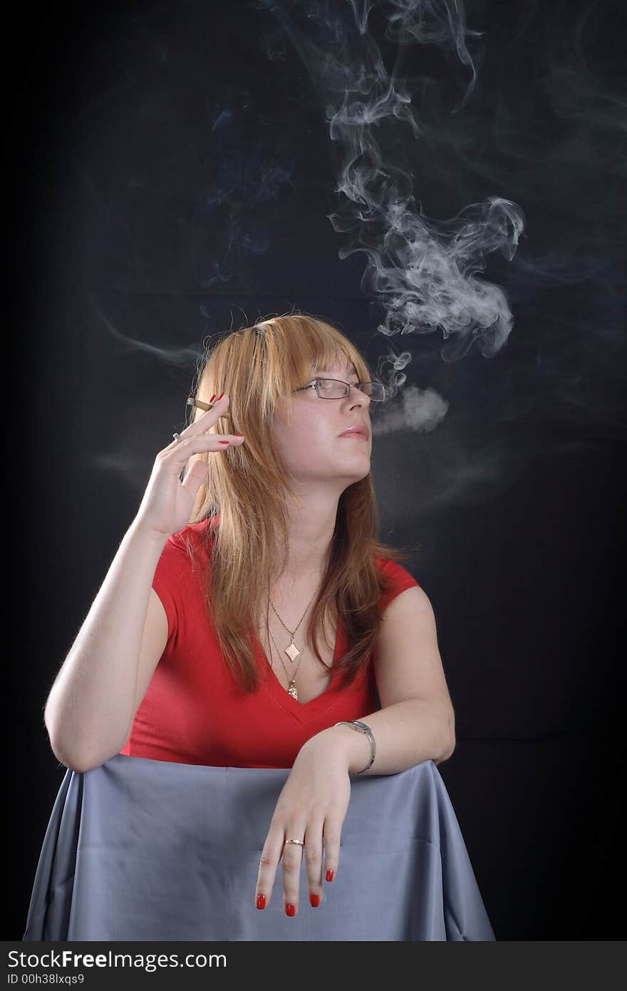 Girl smoking a cigarette on a dark background. Girl smoking a cigarette on a dark background