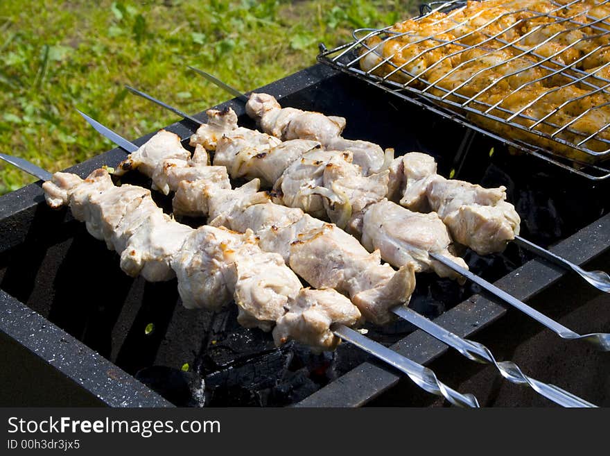 Appetizing shish kebab on the grill with metal skewers. Appetizing shish kebab on the grill with metal skewers