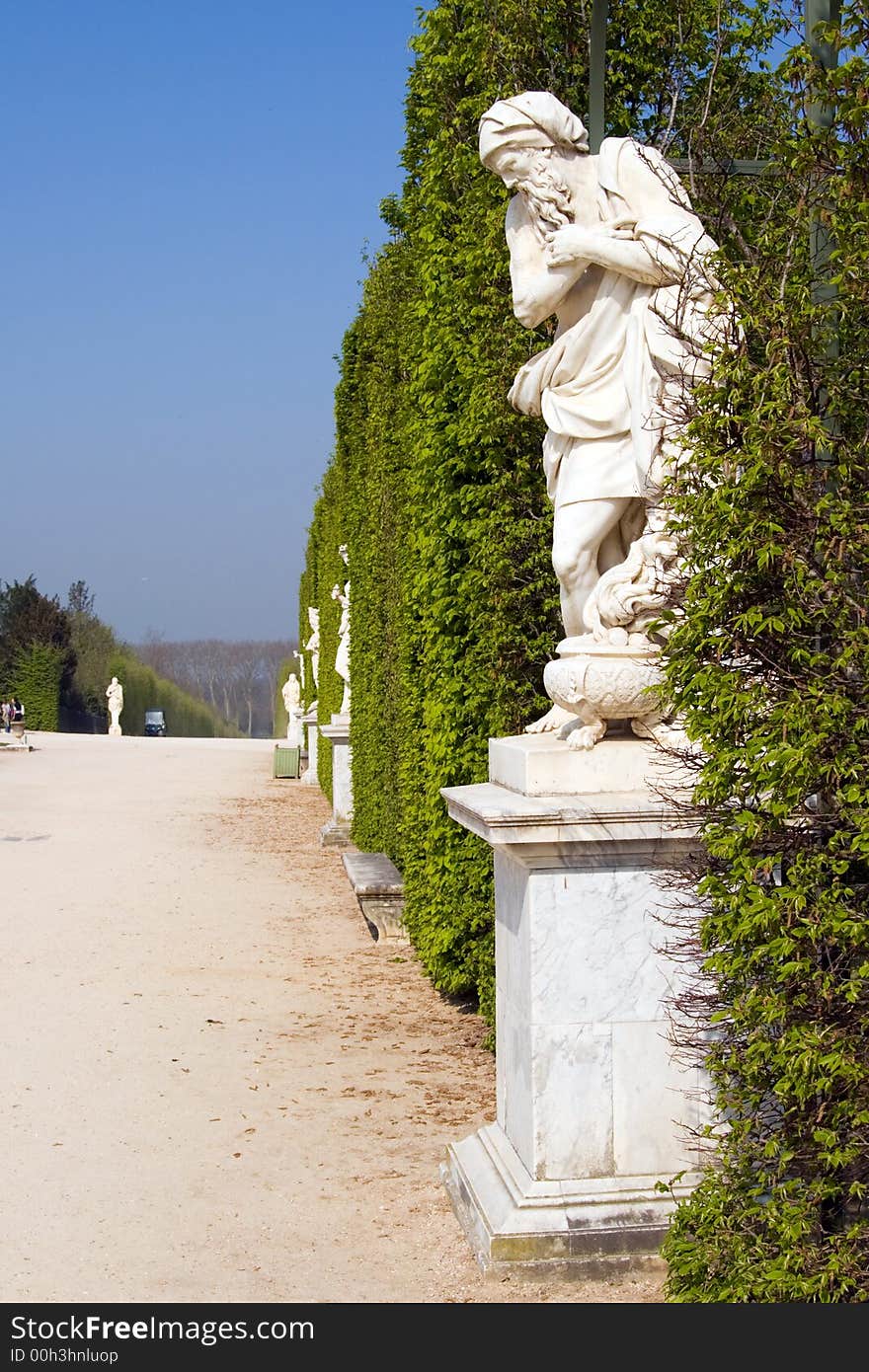 Ancient Sculptures along a row of hedges on the grounds of the Palace at Versailles, France. Ancient Sculptures along a row of hedges on the grounds of the Palace at Versailles, France