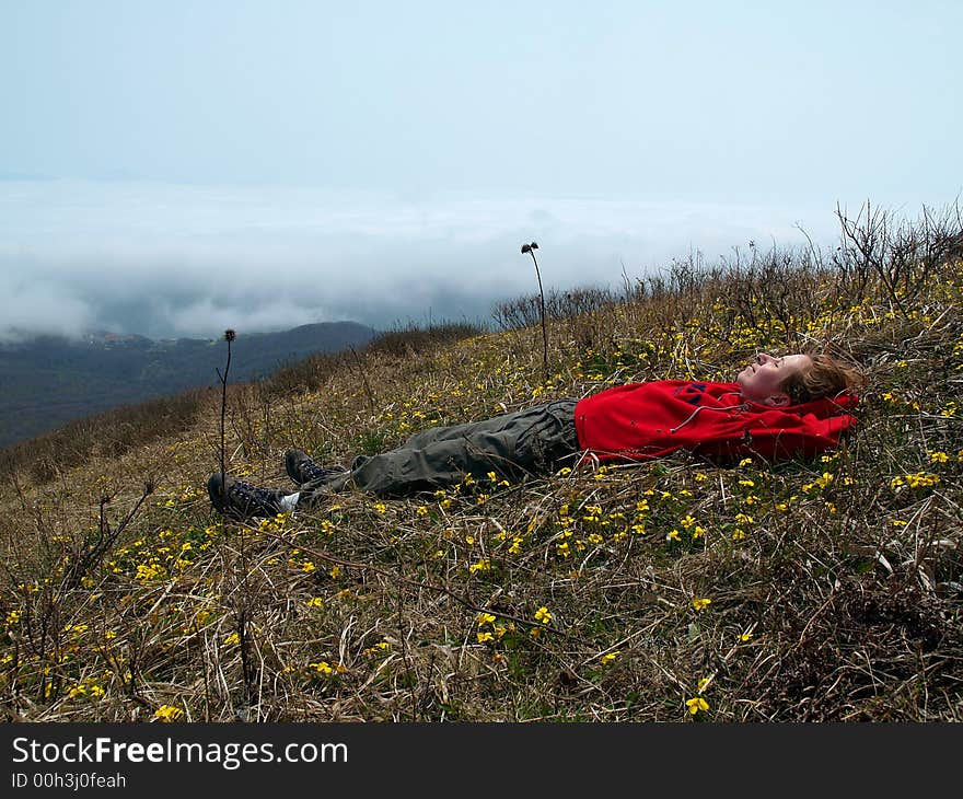 Girl ÐºÑƒÑ‹ÐµÑˆÑ‚Ð¿  on the mountain flower meadow against cloud landscape. Girl ÐºÑƒÑ‹ÐµÑˆÑ‚Ð¿  on the mountain flower meadow against cloud landscape