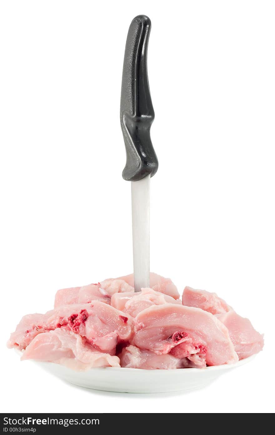 Raw chicken chopped into pieces at the plate with a knife. Raw chicken chopped into pieces at the plate with a knife