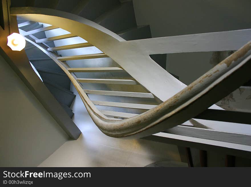 Spiral stairway heading the upper floor in dim light environment. Spiral stairway heading the upper floor in dim light environment