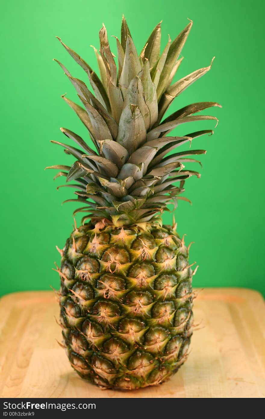 Ripe Pineapple on Green Background