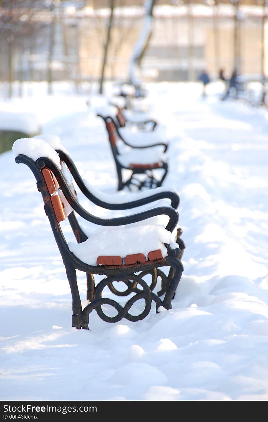 Red benches in a park covered with snow. Red benches in a park covered with snow