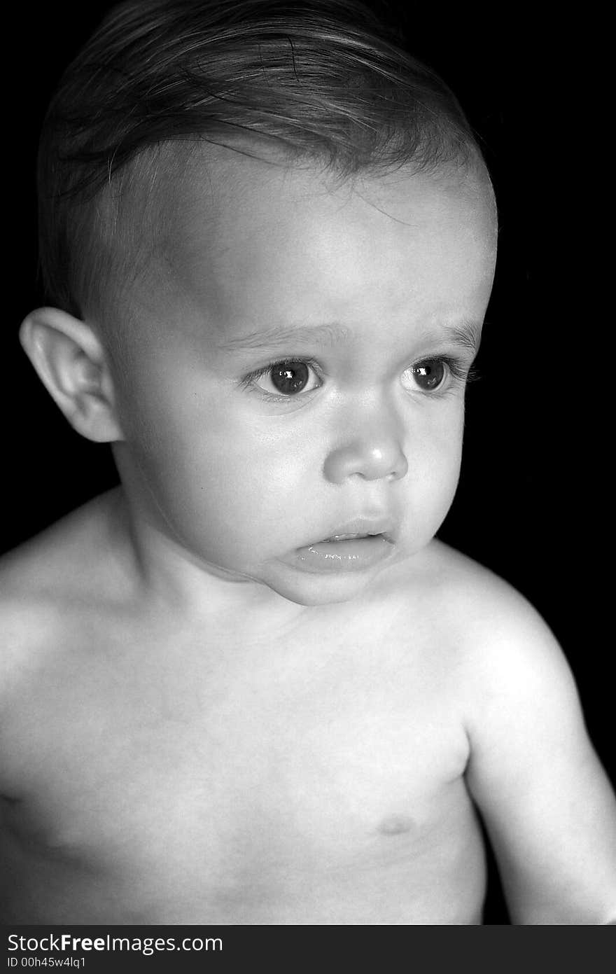 Black and white image of beautiful toddler with a thoughtful look on his face