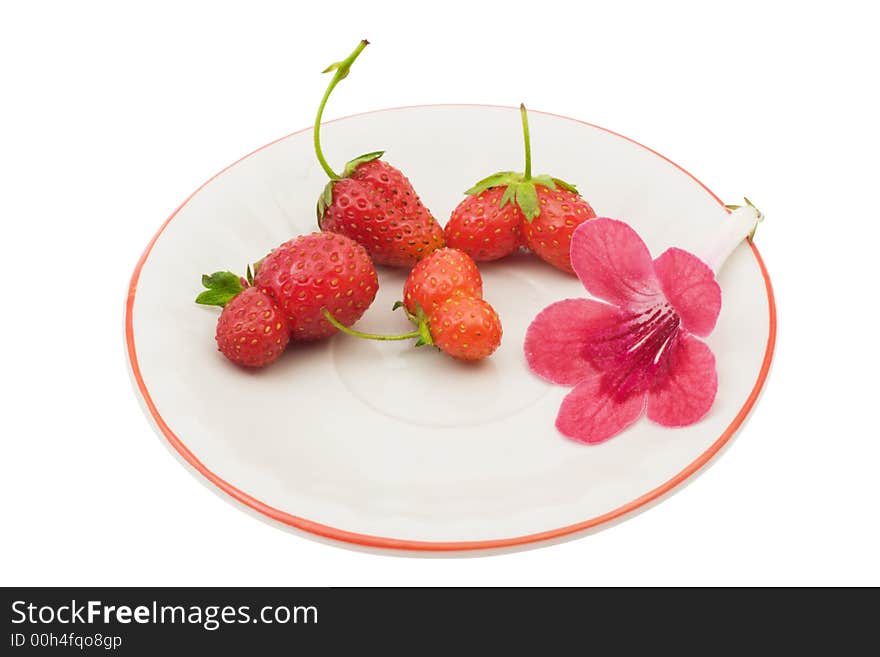 Strawberries and a flower on a saucer, isolated on white background, with clipping path in the file. Strawberries and a flower on a saucer, isolated on white background, with clipping path in the file