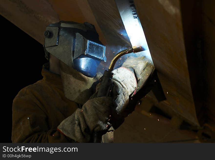 Welder working at night under a ship. Welder working at night under a ship