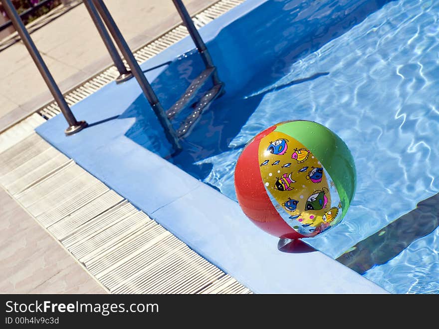 Colorful inflatable ball on water surface in pool. Colorful inflatable ball on water surface in pool