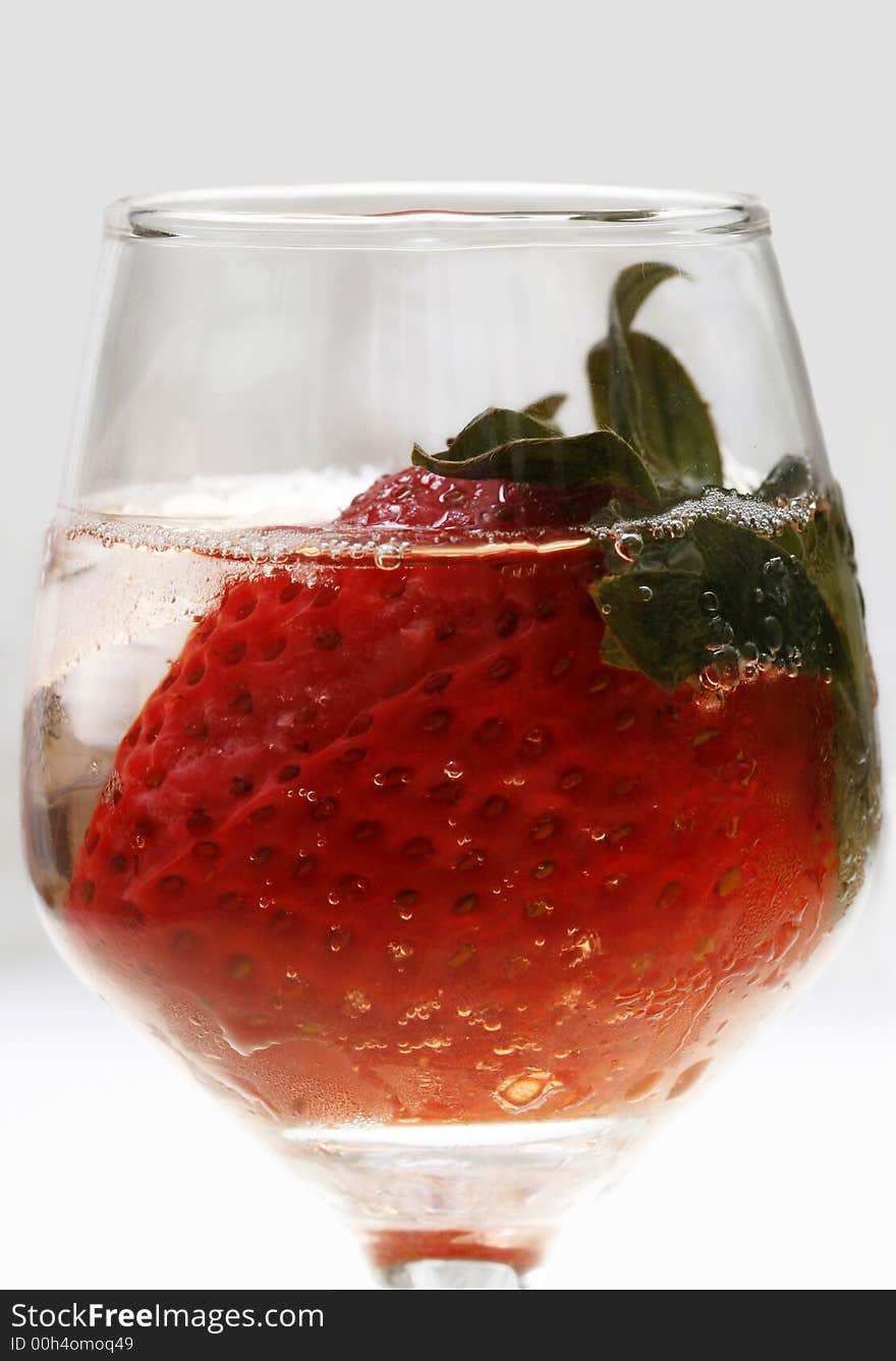 Single strawberry in a glass with ice on white background. Single strawberry in a glass with ice on white background