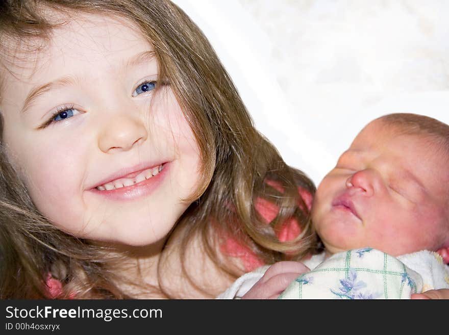 A little girl holding a tiny baby. A little girl holding a tiny baby