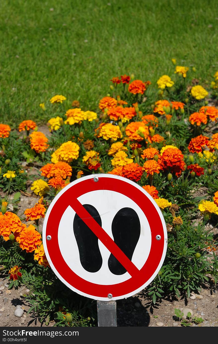 Keep off warning sign with flowers and grass