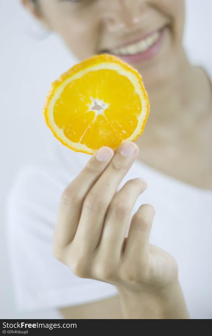 Girl holding piece of orange. Girl holding piece of orange