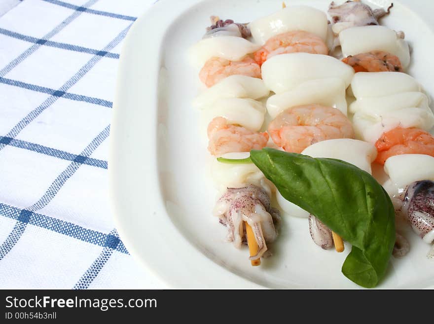 Dish of fresh fish kebabs with basil leaf