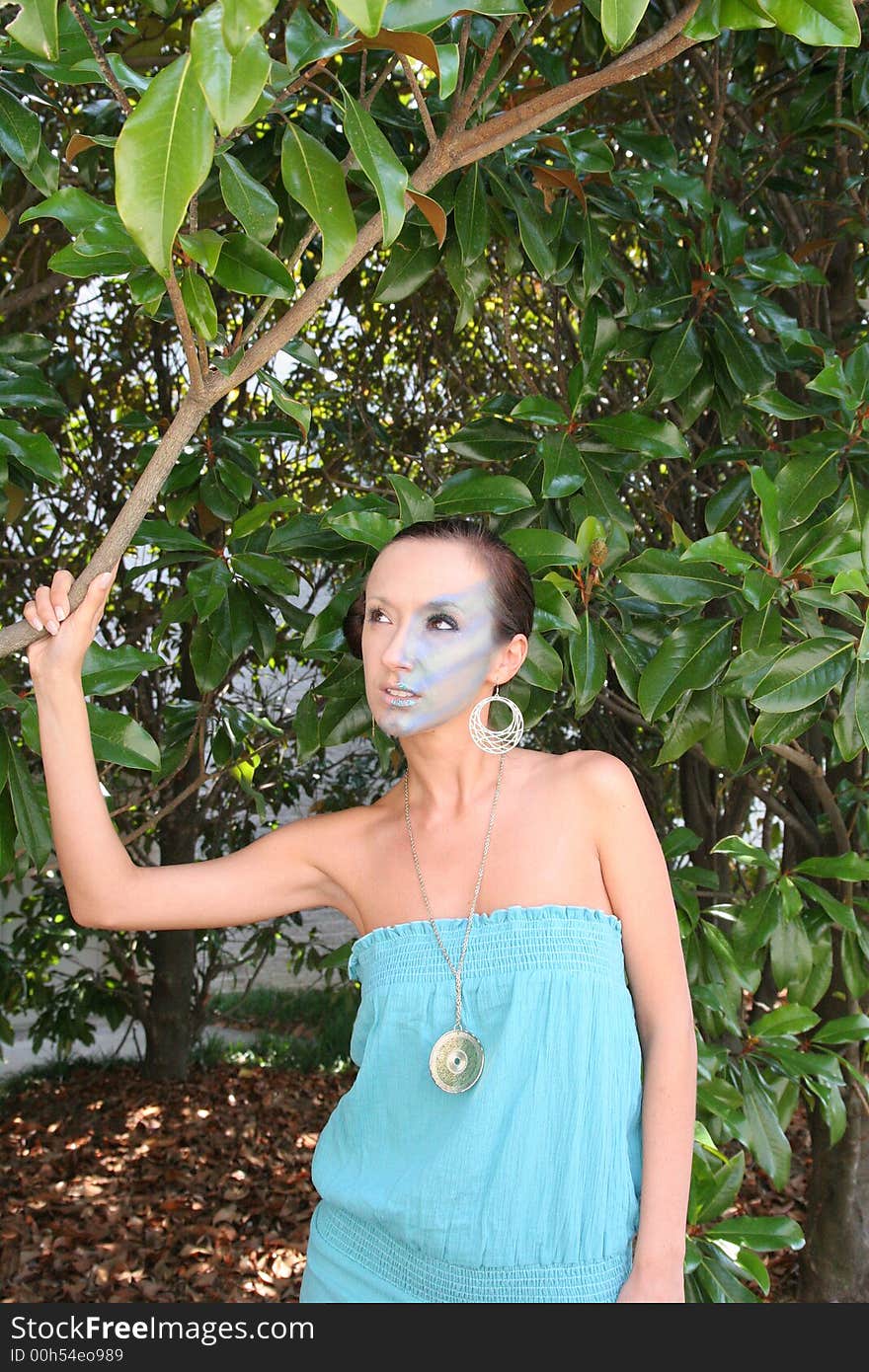 A makeup model standing next to a magnolia tree. A makeup model standing next to a magnolia tree