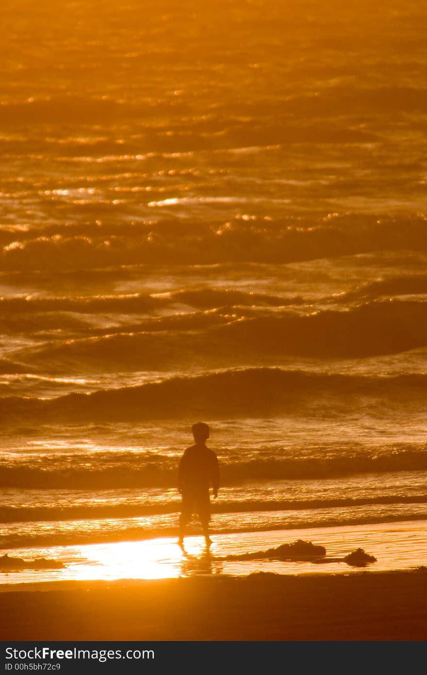 Young boy standing on beach silhouetted by ocean. Young boy standing on beach silhouetted by ocean.