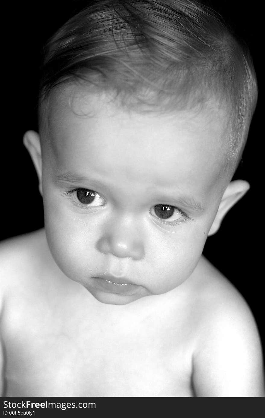 Black and white image of beautiful toddler with a thoughtful look on his face