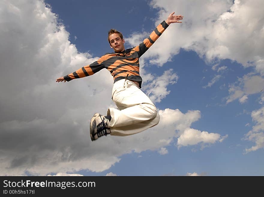 Young man happily jumping against blue sky. Young man happily jumping against blue sky.