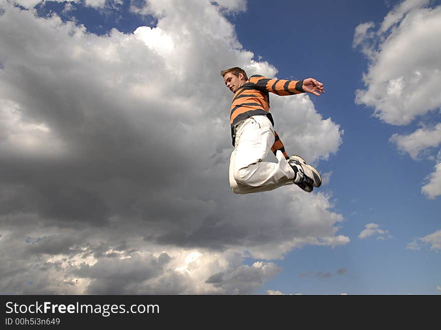 Young man happily jumping against blue sky. Young man happily jumping against blue sky.