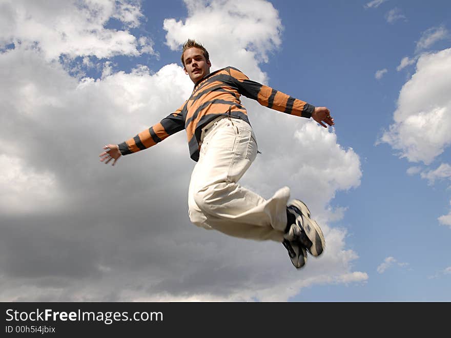 Young man happily jumping against blue sky. Young man happily jumping against blue sky.