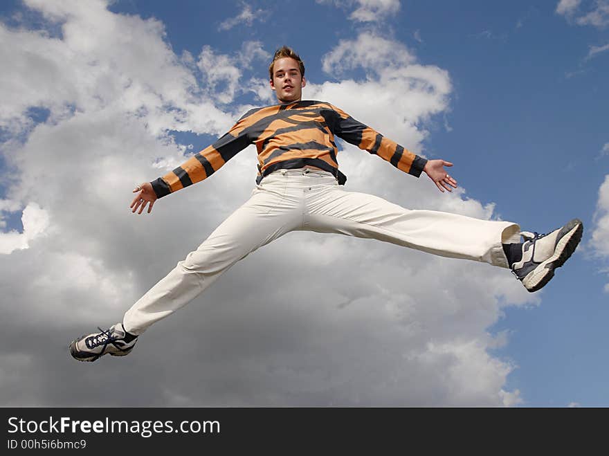 Young man happily jumping against blue sky. Young man happily jumping against blue sky.