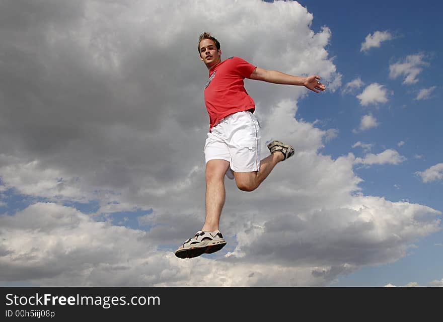 Young man happily jumping against blue sky. Young man happily jumping against blue sky.