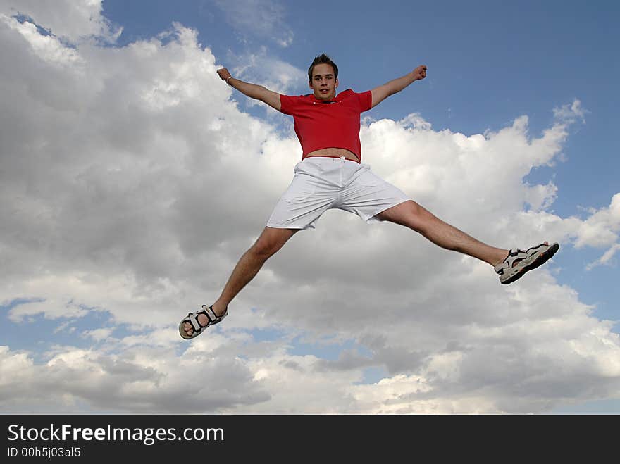 Young man happily jumping against blue sky. Young man happily jumping against blue sky.