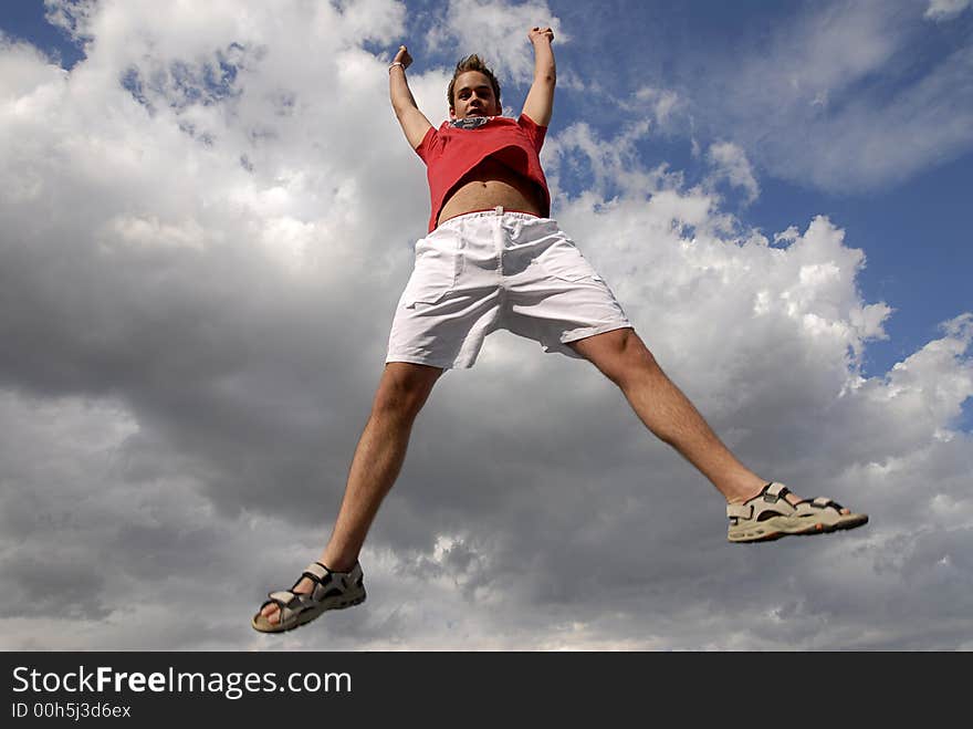 Young man happily jumping against blue sky. Young man happily jumping against blue sky.