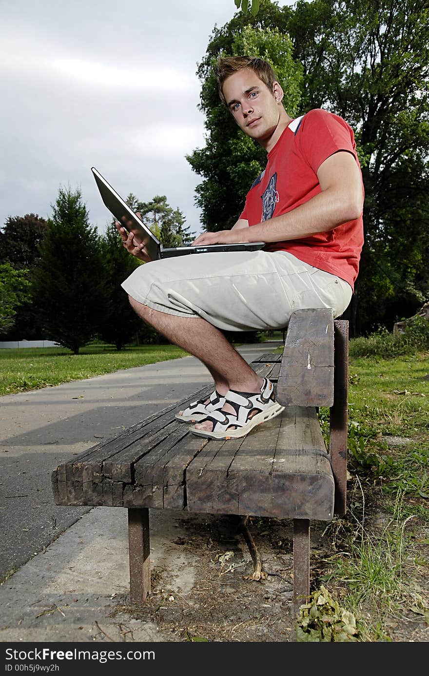 Picture of young man with notebook in park