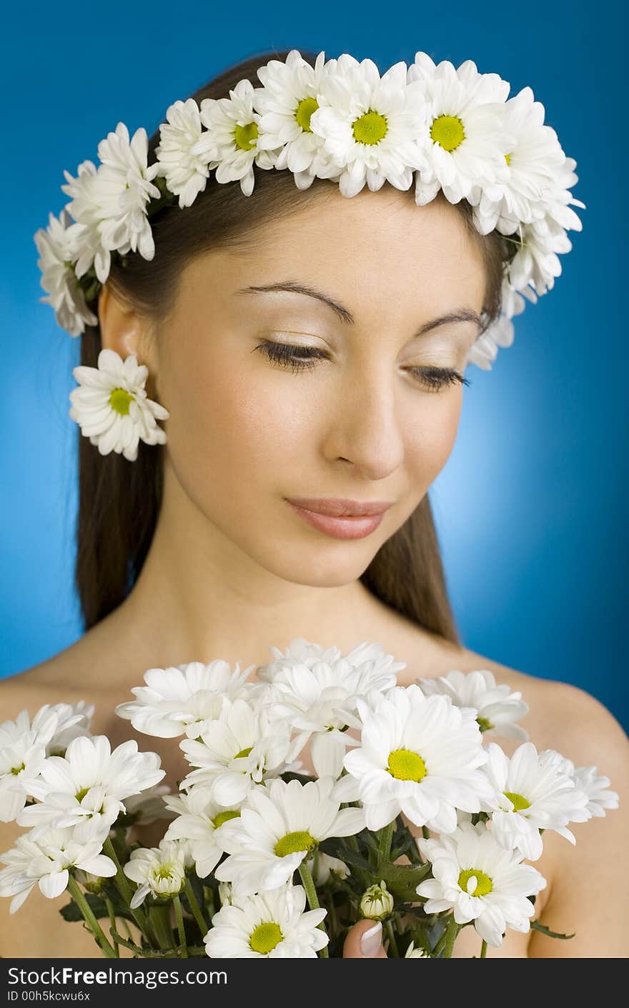 Young, beautiful and  modest woman with bouquet of white flowers. Blue background. Young, beautiful and  modest woman with bouquet of white flowers. Blue background