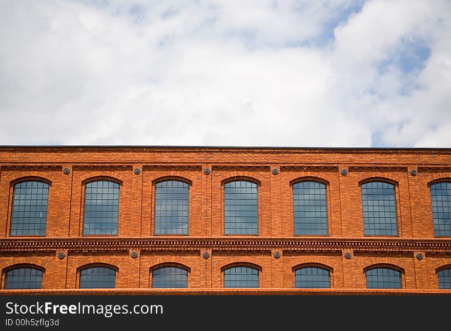 Brick wall background texture on cloudy sky