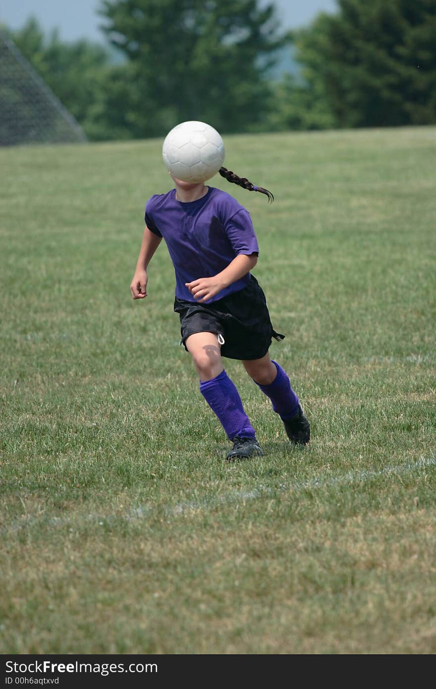 Girl kicking ball at soccer field during a game. Girl kicking ball at soccer field during a game.