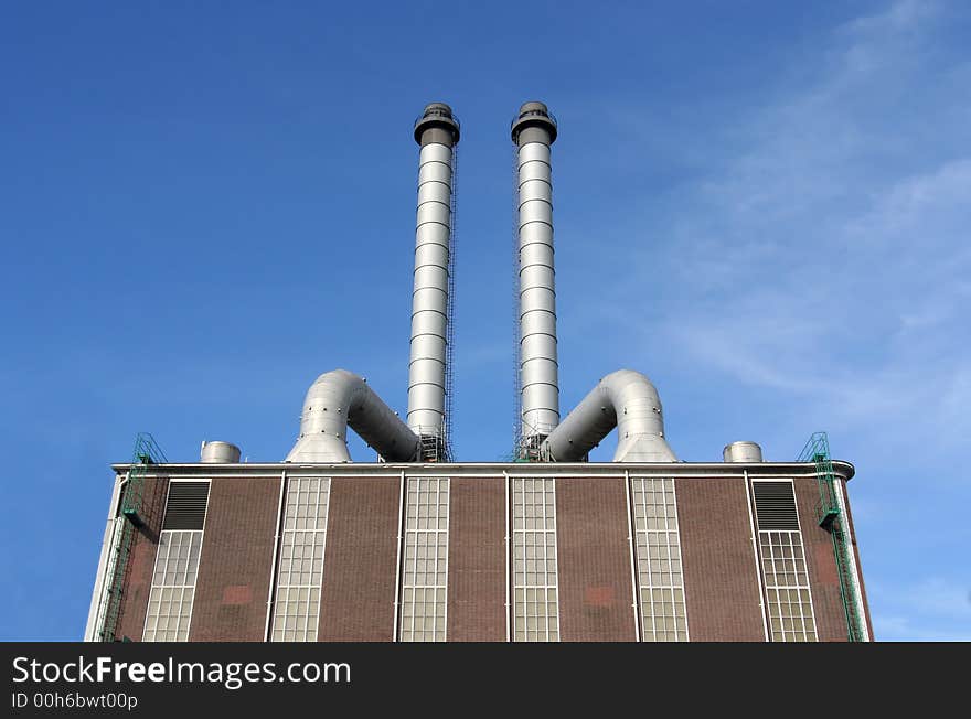 Large pipes on top of a factory making electricity from gas. Large pipes on top of a factory making electricity from gas