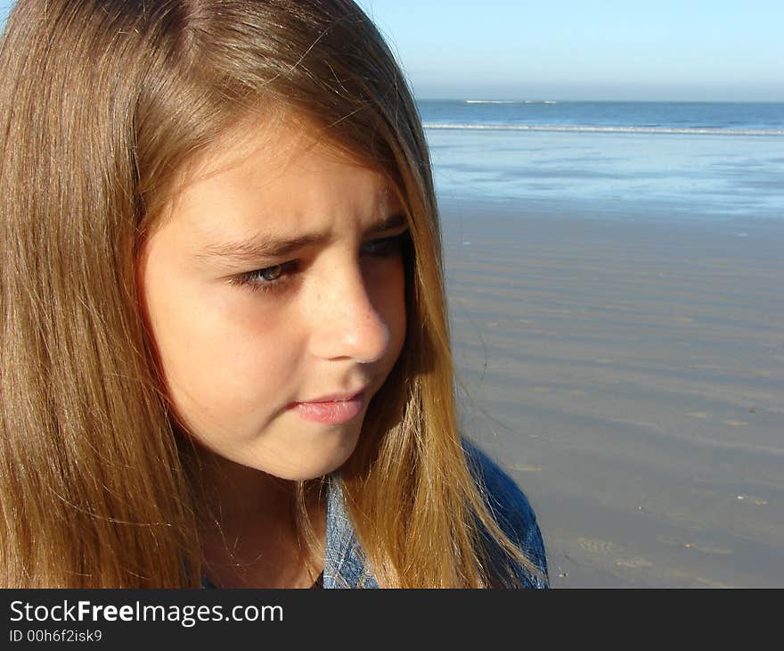 Head & Shoulders shot of young girl standing on the beach. Head & Shoulders shot of young girl standing on the beach