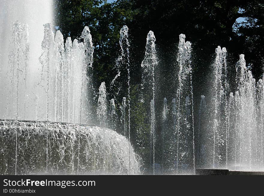 Water of a city fountain with trees in background. Water of a city fountain with trees in background