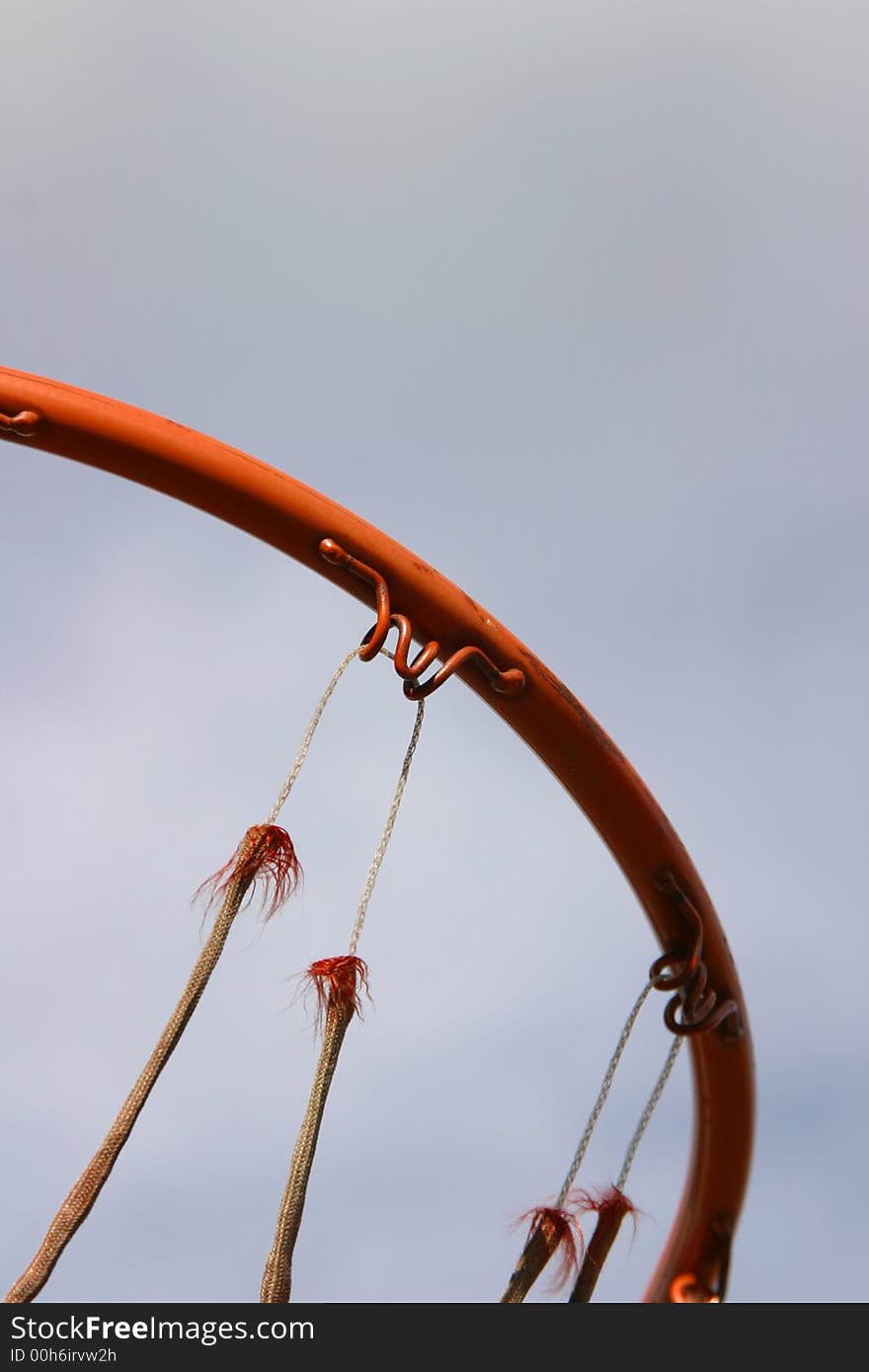 A ring from a basketball hoop with an old and torn net. A ring from a basketball hoop with an old and torn net.