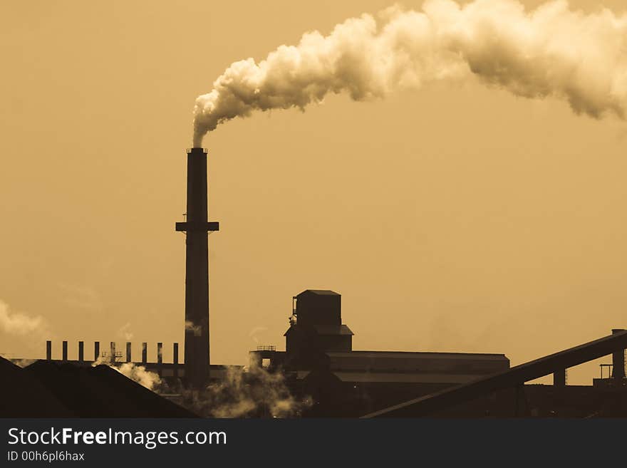 Old-style steelmill smokestack spewing out pollution.