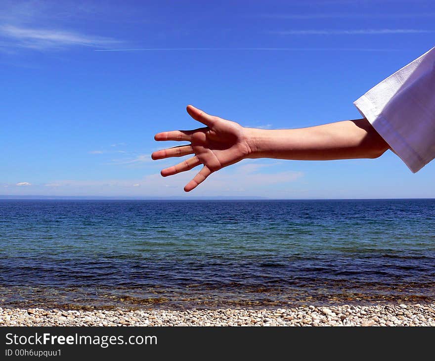 One hand on a background of the sea