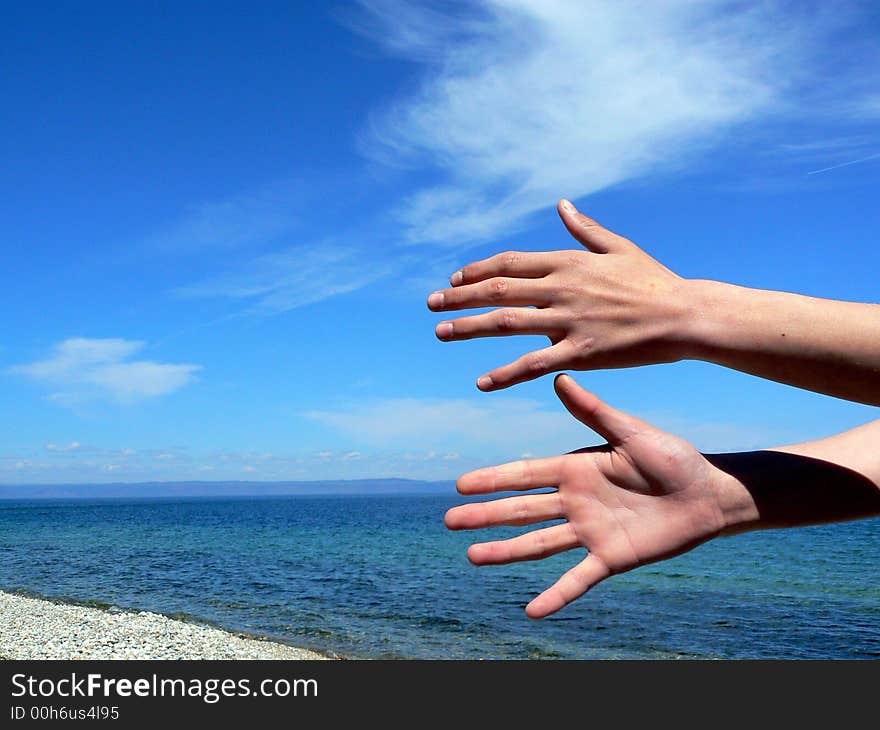 Two hands on a background of the sea