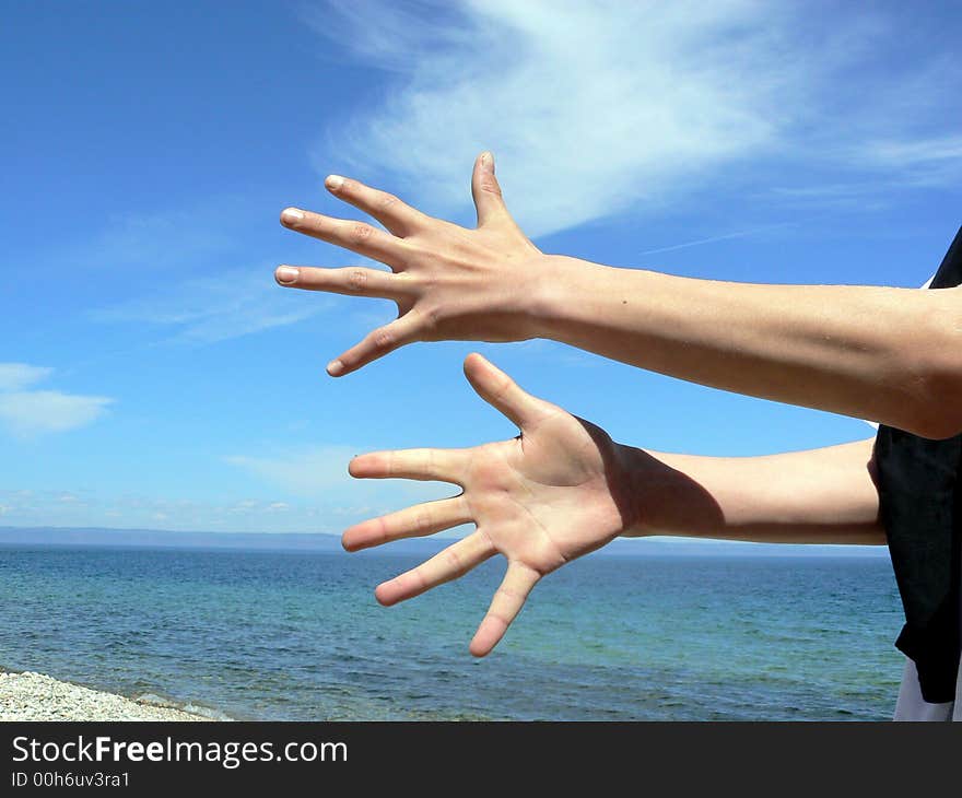 Two hands on a background of the sea